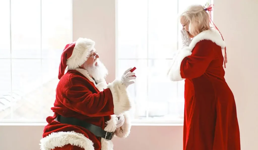 Santa-themed holiday proposal with Santa Claus on one knee proposing to Mrs. Claus, representing festive engagement trends.