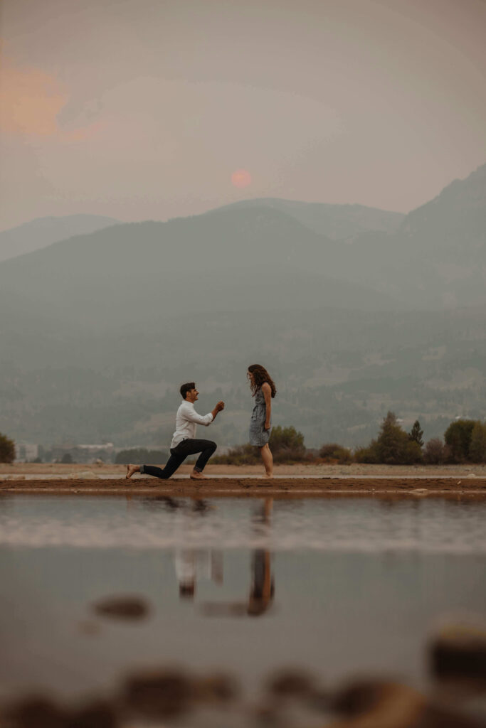 A romantic sunset proposal in the mountains, capturing modern engagement trends with a serene backdrop.