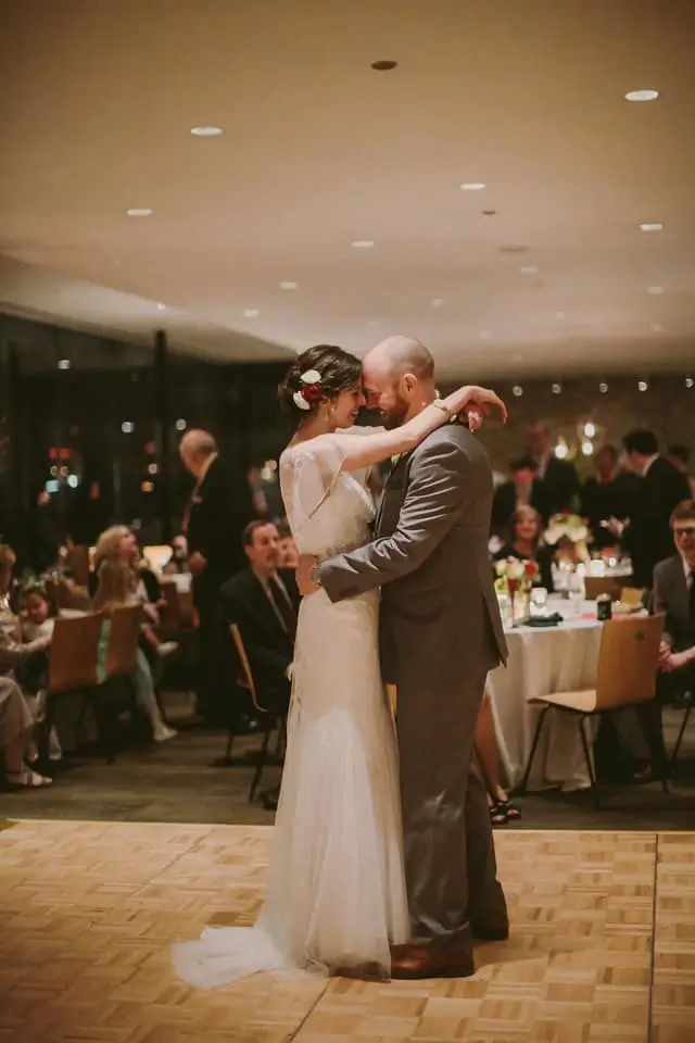 Bride and groom sharing their romantic first dance during wedding reception in an elegant indoor setting.