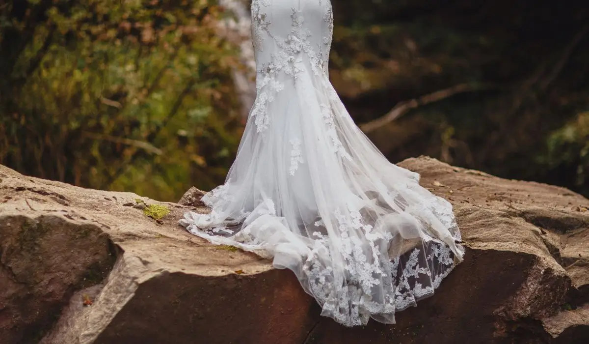 Stunning lace train detail of an outdoor bridal gown with a delicate wedding dress bustle arrangement.