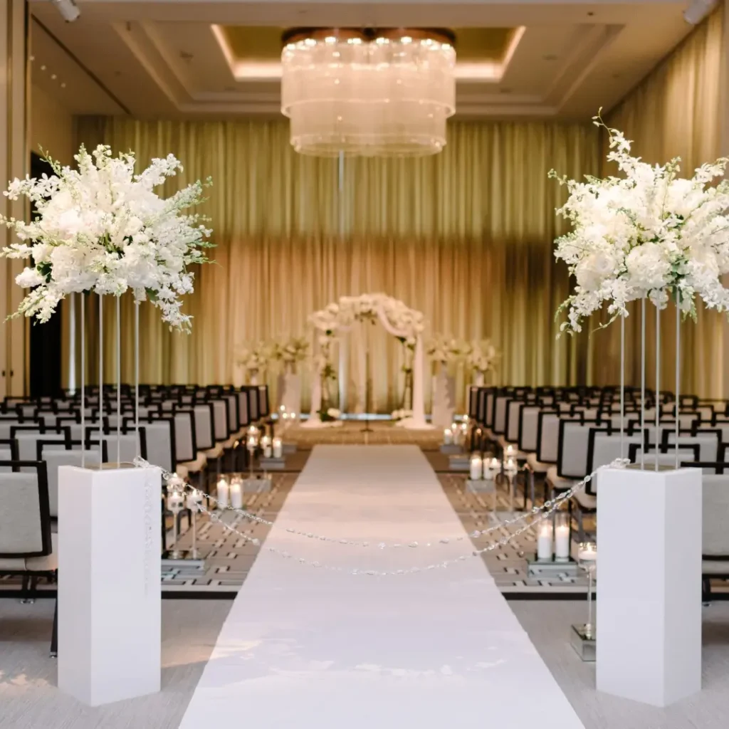 Beautiful wedding ceremony "Room flip" featuring luxurious white decor, elegant floral arrangements, and aisle design.