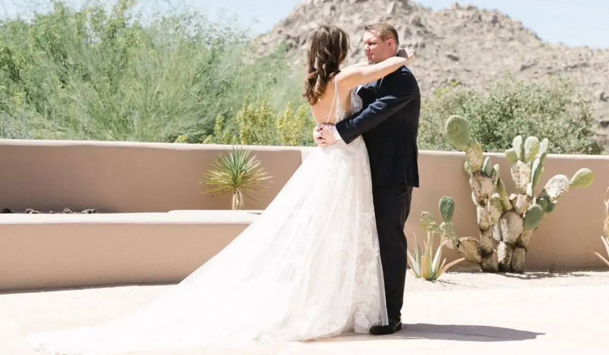 Bride and groom enjoying their first dance in a scenic desert setting with cacti in the background.