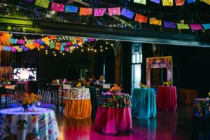 A colorful event room filled with vibrant décor, bold floral accents, and lively thematic details that create an immersive celebration atmosphere.