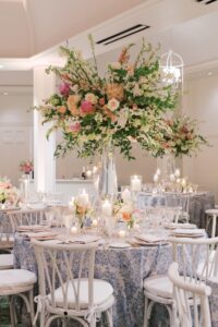 Tall guest table centerpiece featuring pastel spring florals at this luxury Hamptons wedding reception.