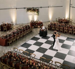 Bride and groom sharing their first dance on a black and white dance floor during their luxury wedding in the Chicago suburbs at Providence Vineyard.