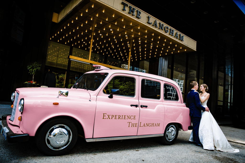 couple standing in front of iconic pink car at the Langham hotel in Chicago