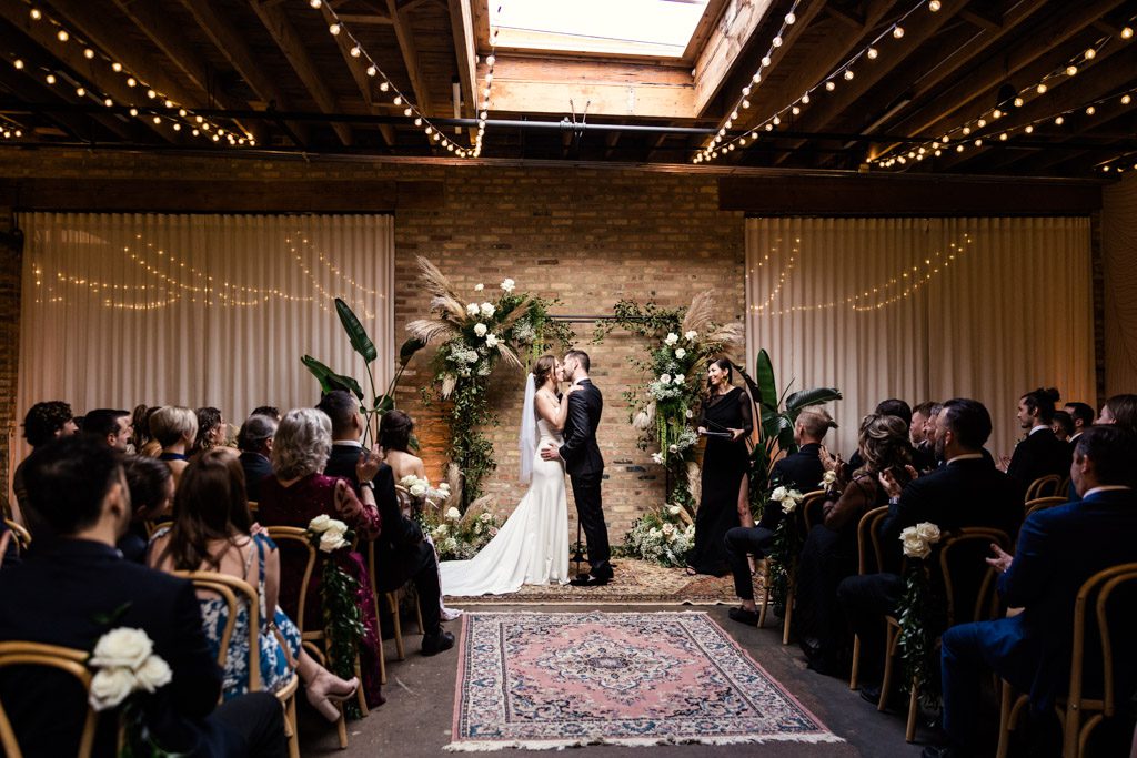 bride and groom kisisng at alter in chicago loft wedding venue