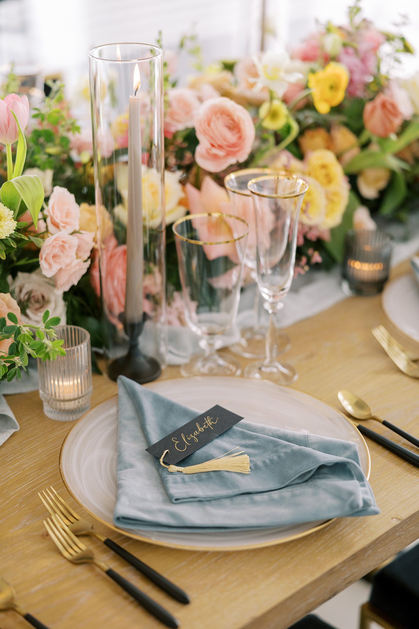 Elegant wedding tablescape featuring a velvet napkin, gold‑rimmed plate, personalized place card, and lush floral centerpiece, refined and styled by Effortless Events during partial wedding planning session