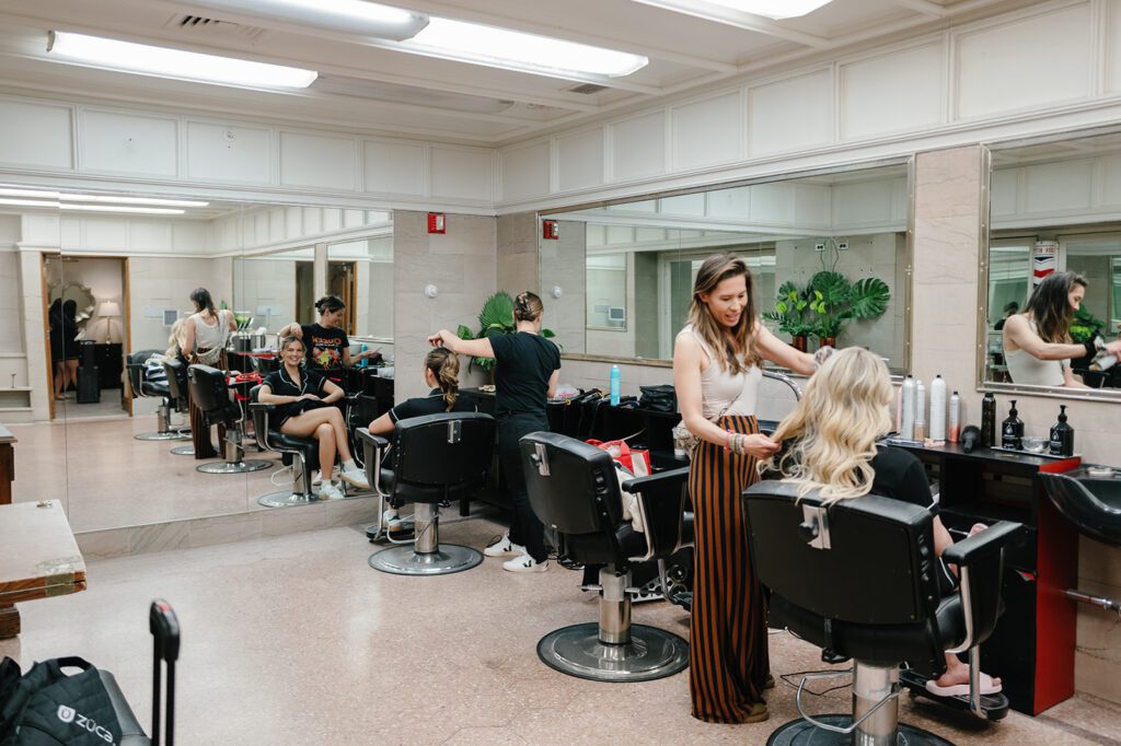 Wedding day hair and makeup prep with stylists working in salon before ceremony at luxury chicago venue.