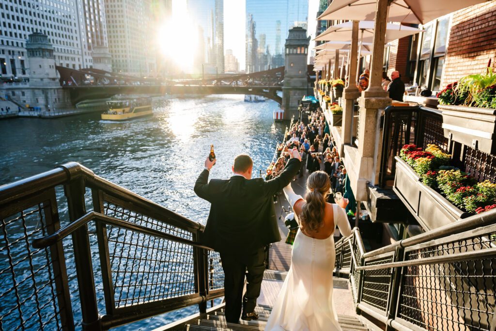 Bride and groom walking down stairs towards guests at River Roast Chicago Wedding