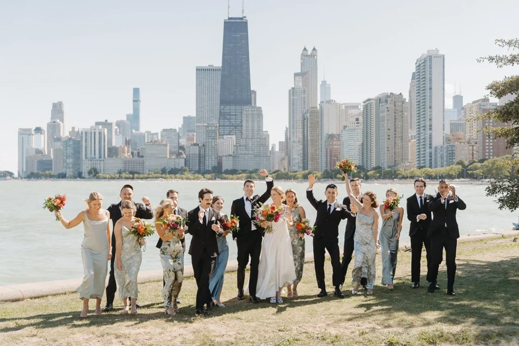 Wedding party celebrating outdoors near the Chicago lakefront, with the skyline and waterfront creating a dramatic urban backdrop.