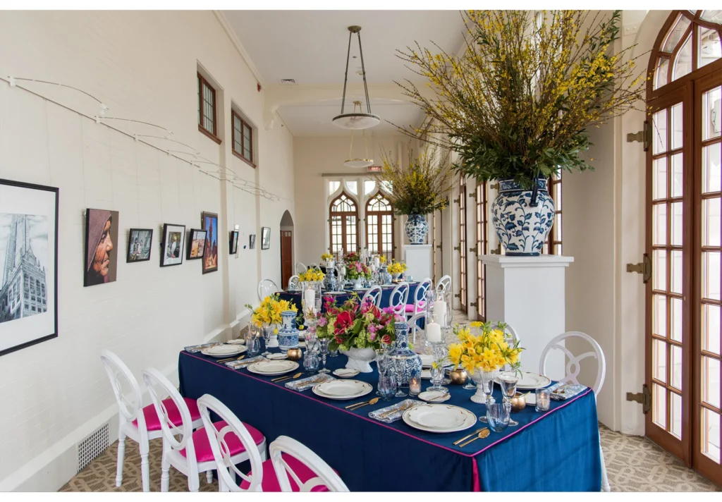the Gallery at university club in Chicago with blue tables, pink florals, porcelain vases, and arched windows.