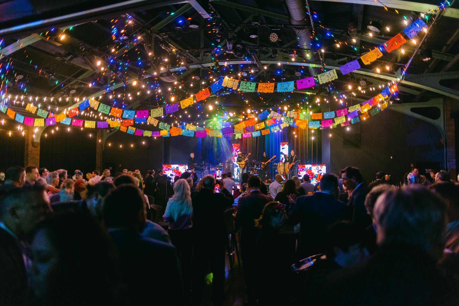 Festive indoor celebration with papel picado and live band