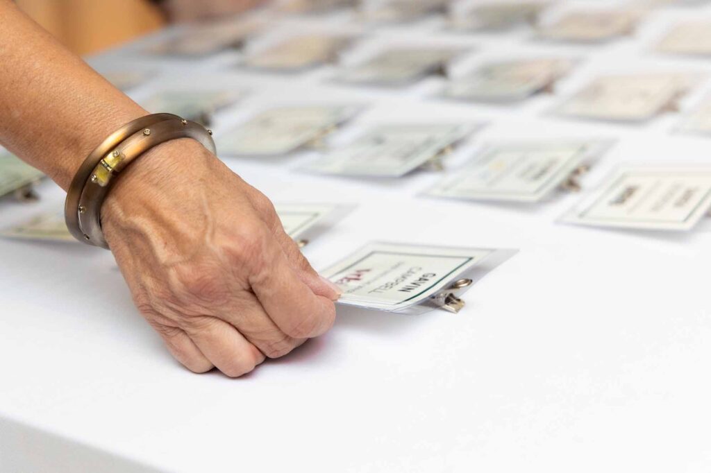 hand touching a name tag with gold bracelet
