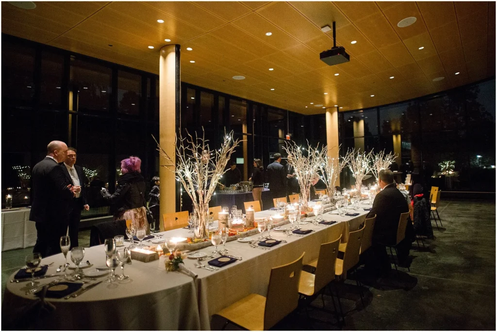 Elegant indoor Morton Arboretum venue with illuminated branch centerpieces and modern architectural backdrop