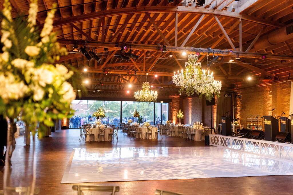Elegant Chicago reception with exposed beams, chandeliers, and glossy dance floor for festive weddings and galas.