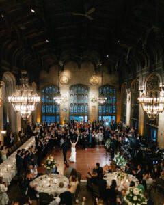 Couple’s first dance during a university club of chicago wedding in Cathedral Hall with Gothic architecture, chandeliers, and guests surrounding the dance floor.