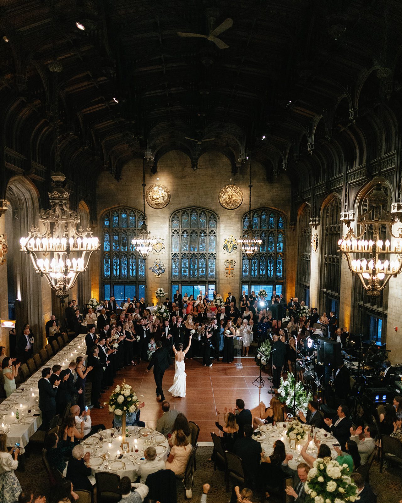 Couple’s first dance during a university club of chicago wedding in Cathedral Hall with Gothic architecture, chandeliers, and guests surrounding the dance floor.
