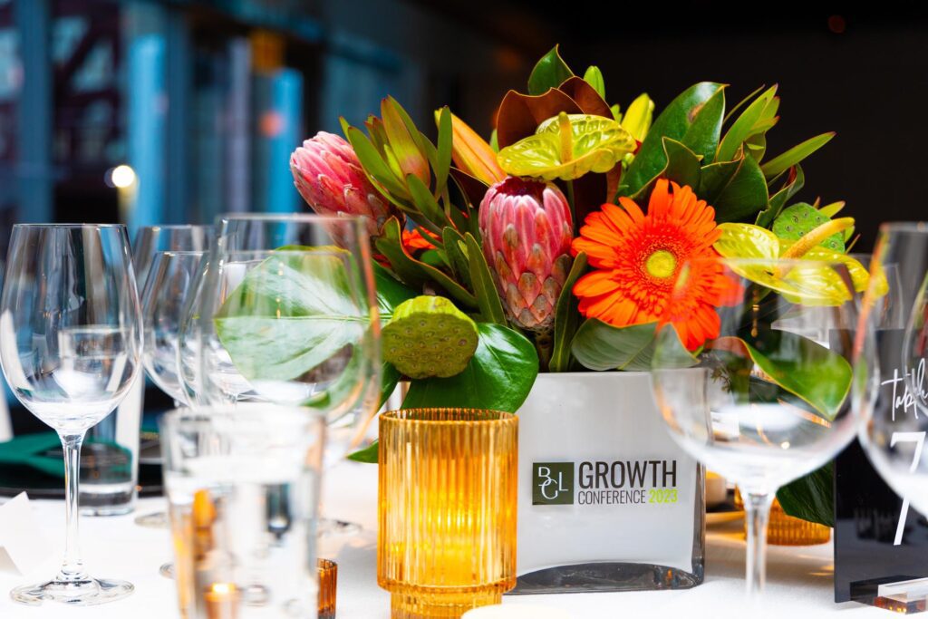 Elegant VIP dinner tablescape featuring branded floral arrangements and refined décor at the Chicago Financial Growth Conference.