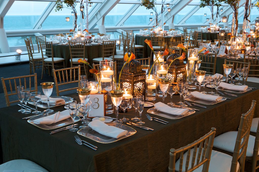 nightime wedding at the Adler Planetarium with orange floral and gold chairs