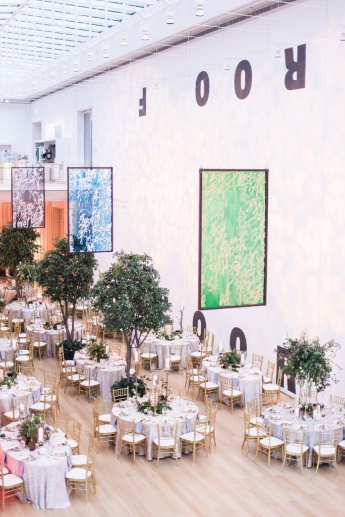 Luxury Griffin Court wedding reception setup at the Art Institute of Chicago with tall greenery and modern museum architecture.