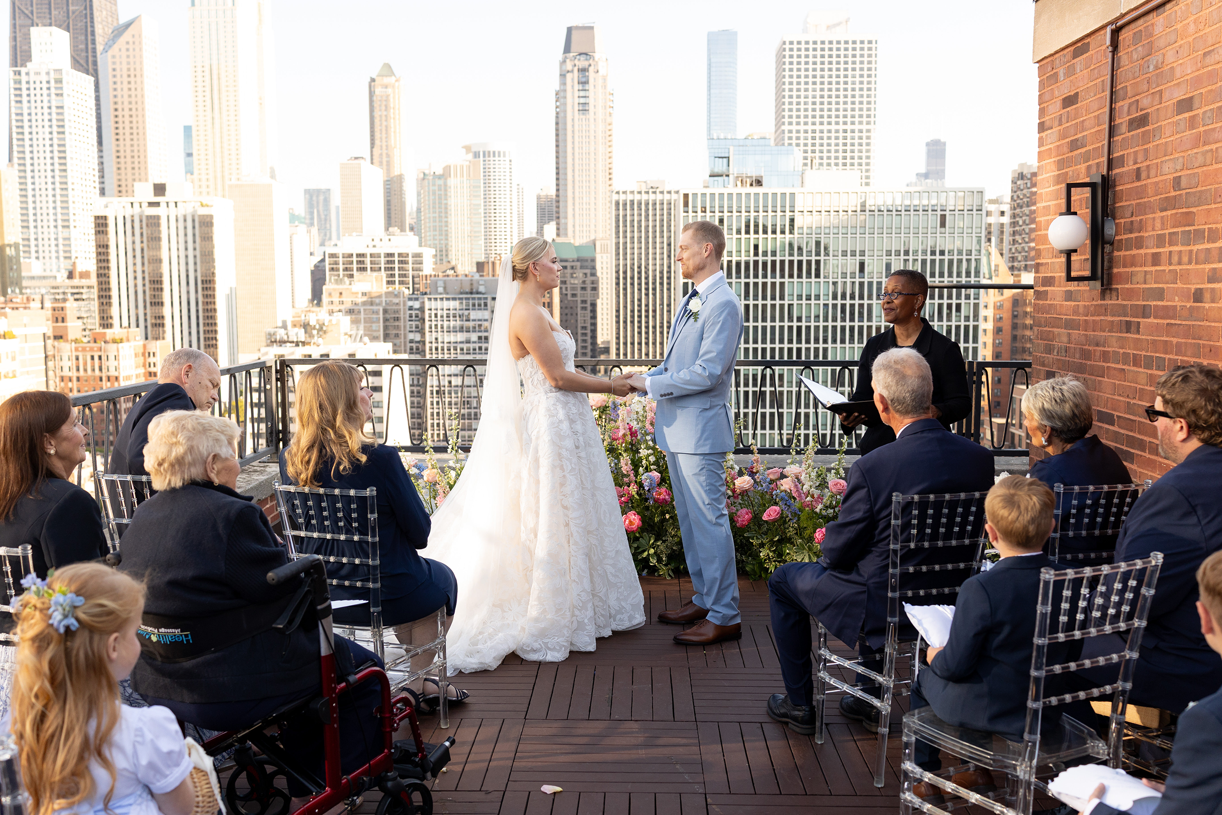 Bride and groom exchanging vows during an intimate rooftop wedding ceremony in Chicago with sweeping downtown skyline views.