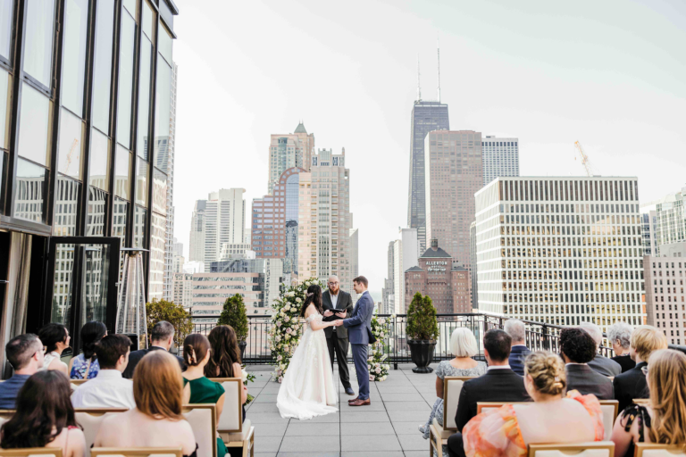 Bride and groom exchanging vows during a rooftop wedding ceremony at The Gwen in Chicago with sweeping downtown skyline views.