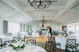 Bride and groom in elegant Chicago ballroom wedding reception with chandeliers, floral centerpieces, and natural light.