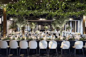 Lush Chicago reception with hanging greenery, candlelit tables, and tall trees for romantic, nature-inspired weddings.