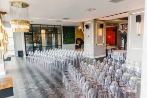 Elegant Chicago event space with acrylic chairs, chandeliers, and gold accents for upscale ceremonies and receptions.