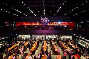 Bustling Chicago food hall with communal tables and vendor stalls, ideal for casual group events and tastings.