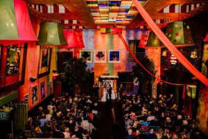 Colorful Chicago wedding ceremony in an artistic venue with whimsical decor, stained glass ceiling, and bold accents.