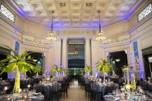 Historic Chicago ballroom with coffered ceiling, tropical centerpieces, and ambient lighting for luxe receptions and galas.