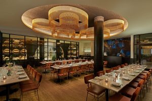 Upscale Chicago restaurant with sculptural lighting and wine barrel wall, ideal for private events and dinners.