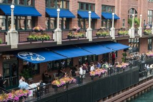 Riverside Chicago restaurant with colorful flower boxes and outdoor seating, perfect for casual events and group dining.