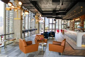 Modern Chicago lounge with velvet sofas, city views, and gold lighting for upscale receptions and cocktail events.